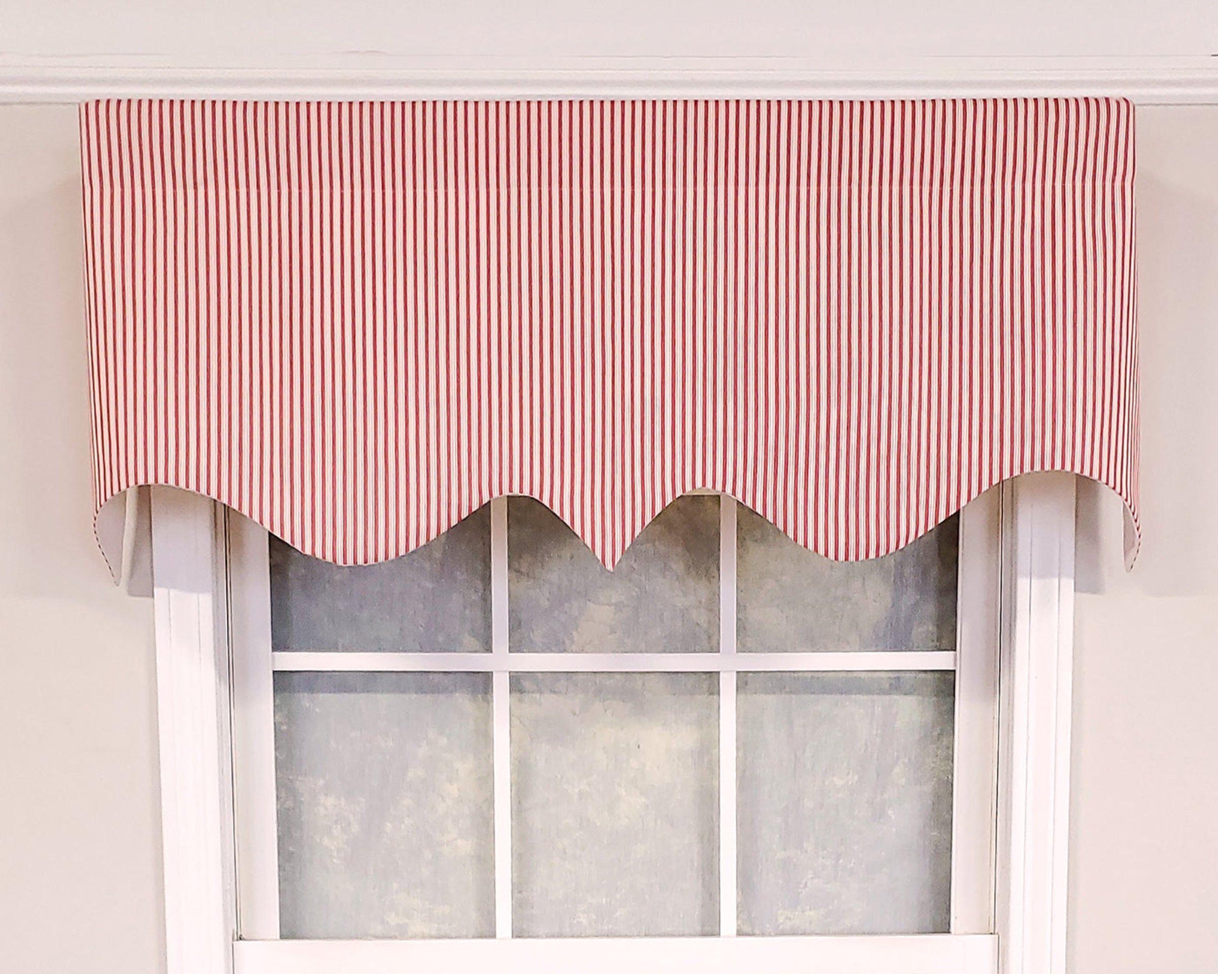 Window with a red striped valance against a white wall