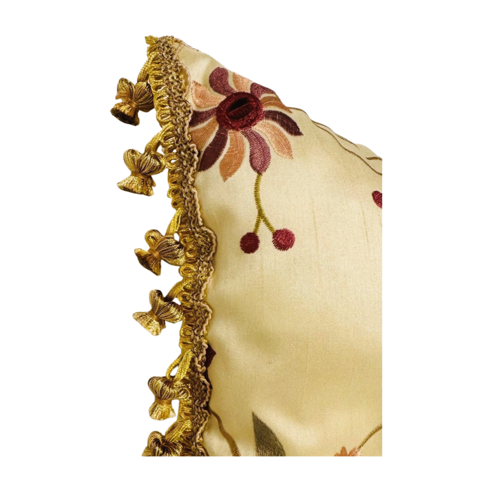 Decorative pillow with floral embroidery and gold tassels on a gold background. Holiday throw pillow